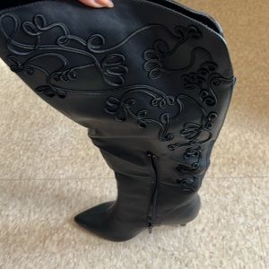 Black heeled boots with detailing go right under the knee